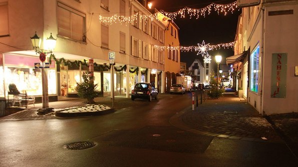 Hell erleuchtete Gebäude in einer Straße mit nicht abgeschirmten Straßenlaternen